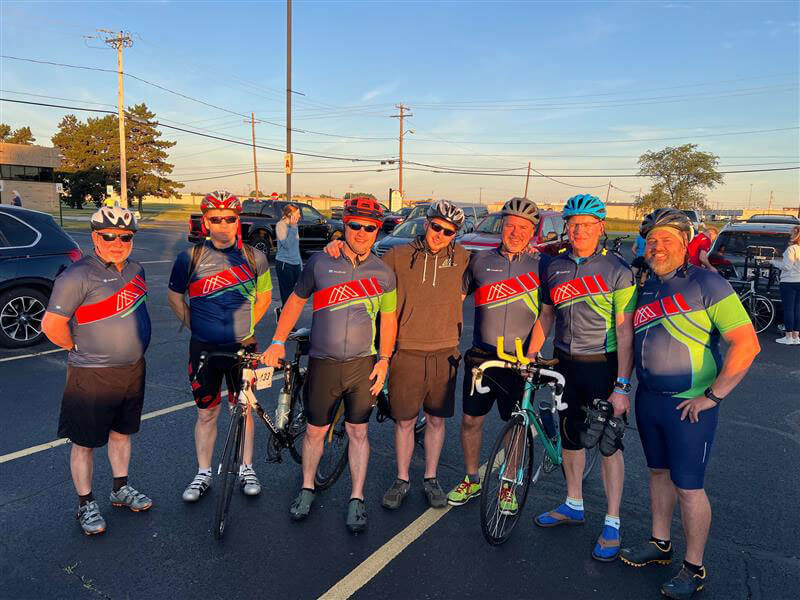 Bike to the Bay, The McAlear Group team members lined up with bikes and jersey and helmets on.